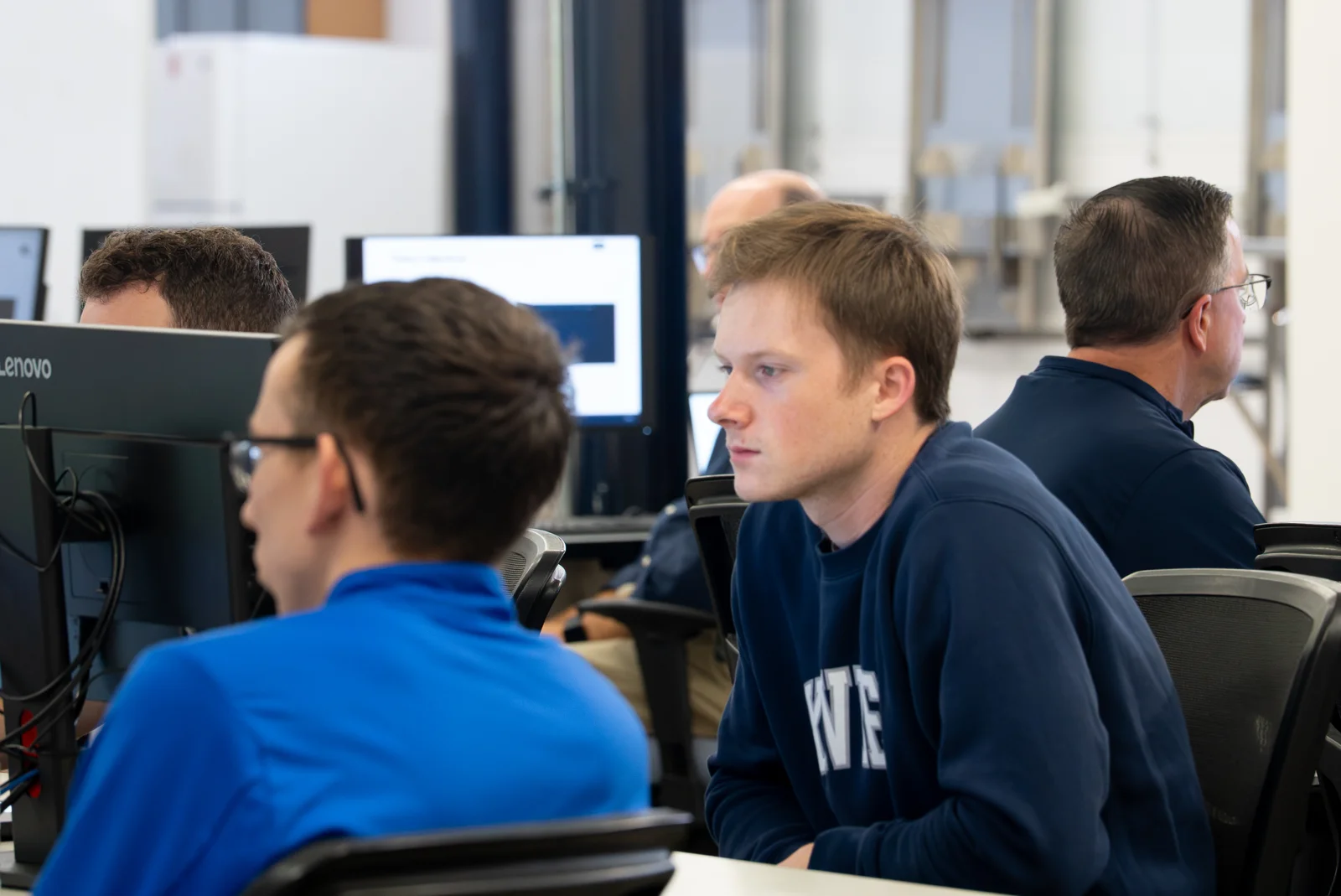 Participants learning at desktop computers in the Generative AI Teaching Lab.