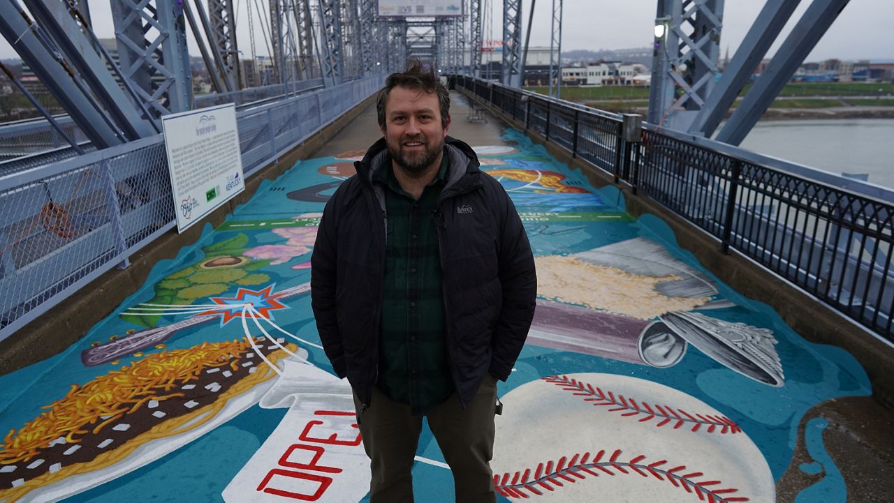 Mural artist Matthew Grote standing on the painted Ohio–Kentucky pedestrian bridge.