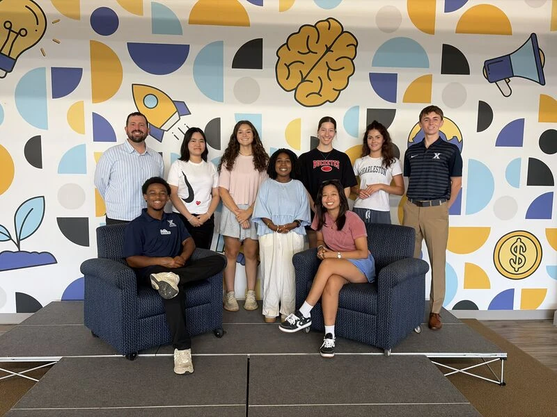 The NEXT AI at Work cohort gathered in front of the colorful mural at The Loop.